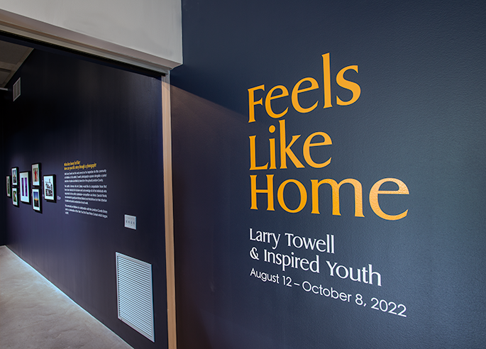 Navy Wall with text Feels Like Home Larry Towell & Inspired Youth