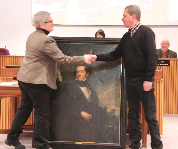 Donor with gifts of art shaking hands with Curator, Lisa Daniels