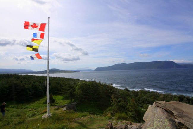 Flags on hillside overlooking water