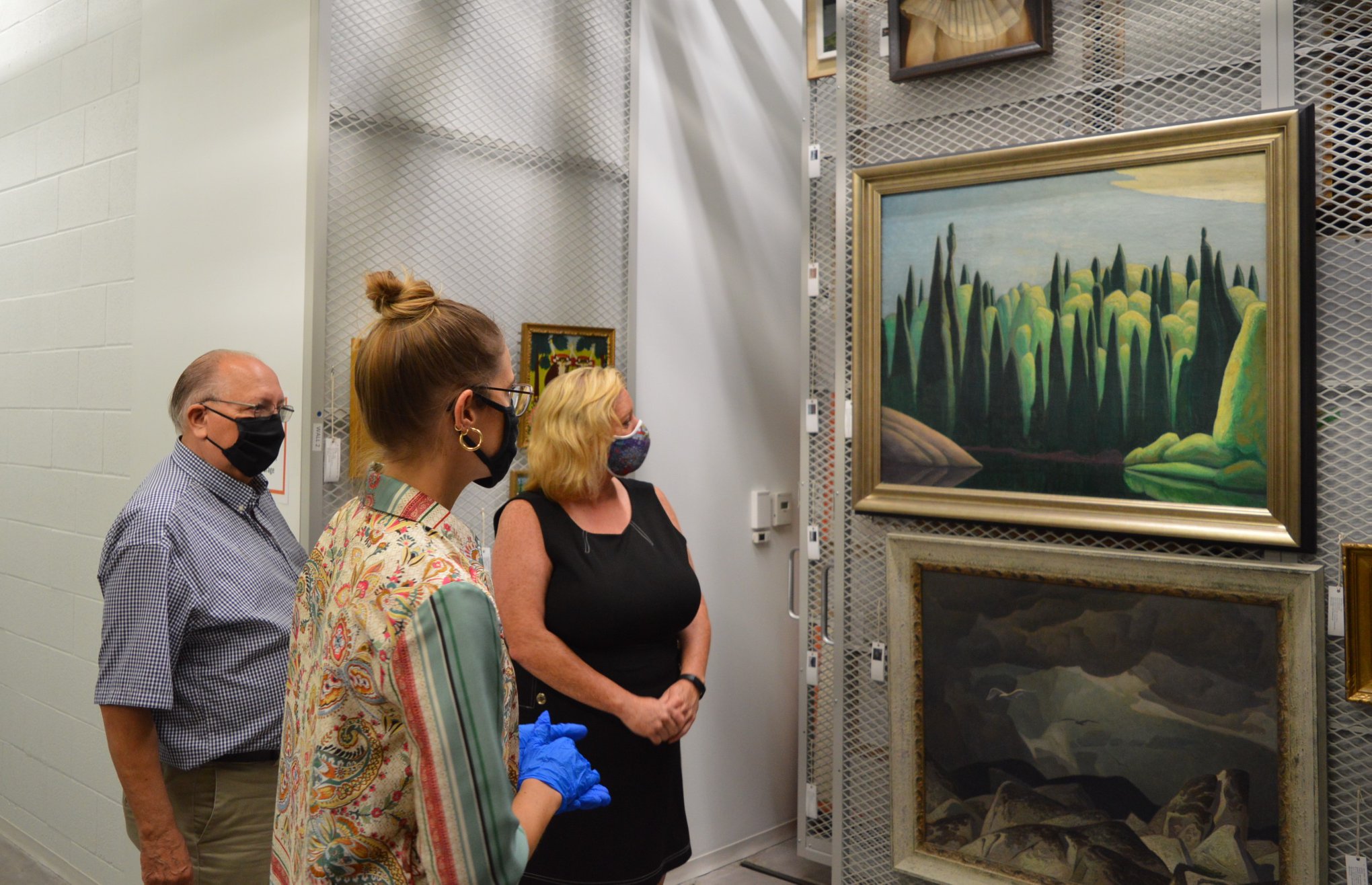 Curator Sonya Blazek showing Minister Lisa MacLeod and Bob Bailey works from the permanent collection