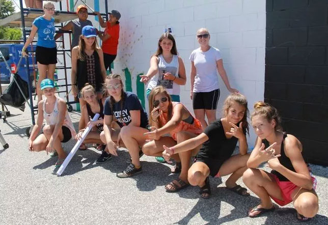 Teenage artists painting mural