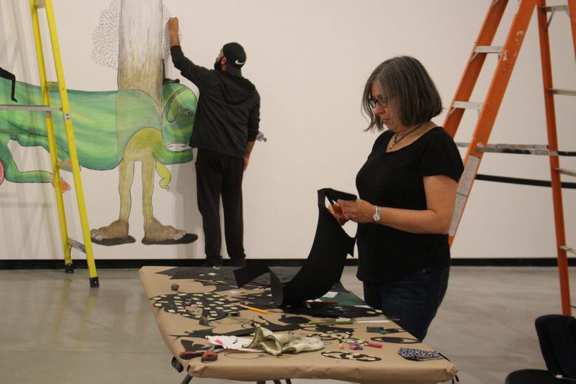 Ilyana Martinez, foreground, and Erik Jerezano work Wednesday on a mural at the Judith and Norman Alix Art Gallery in Sarnia. They are members of the Toronto-based Z'otz Collective. The gallery is reopening to the public Saturday.