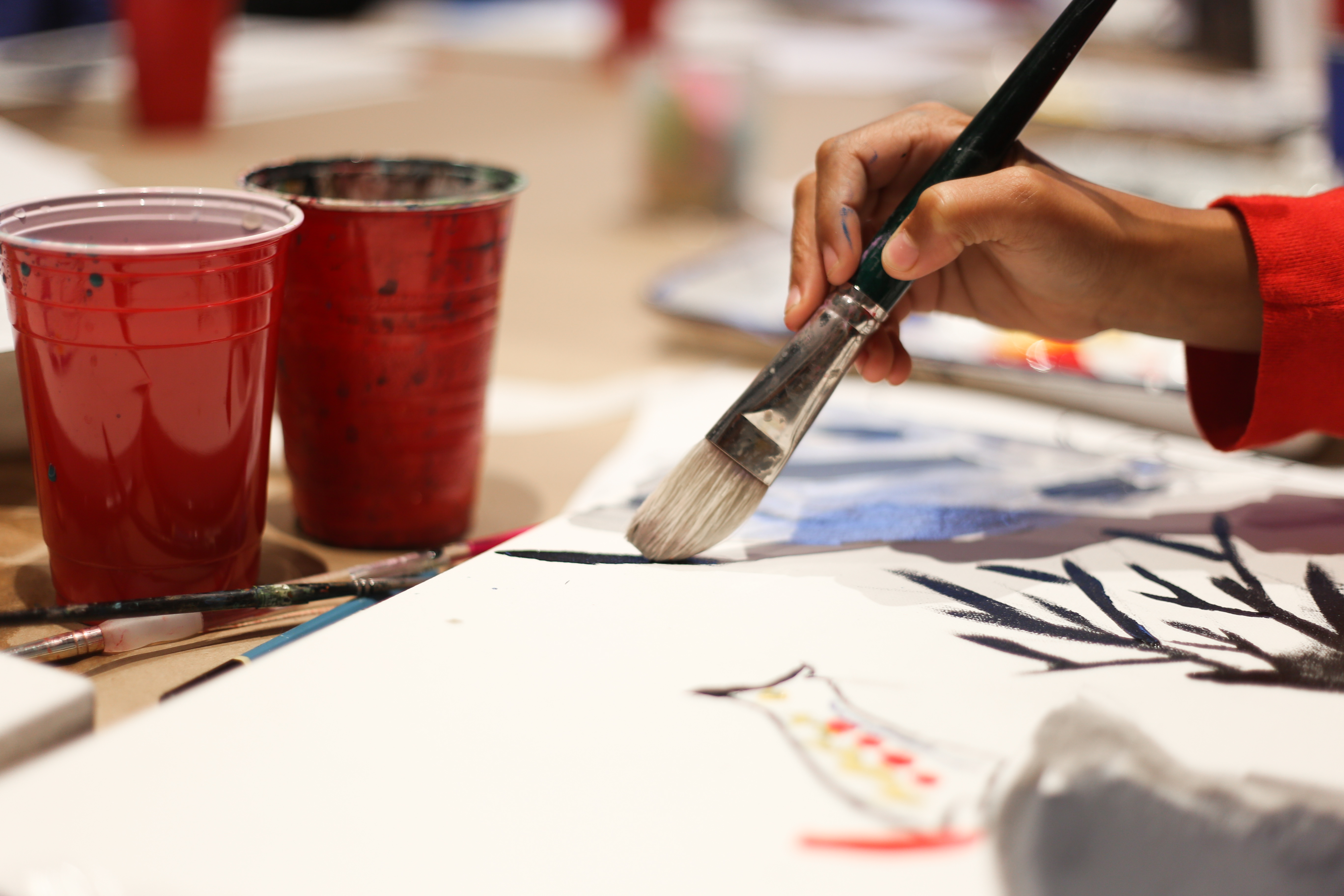 a hand of a person holding a brush to paint