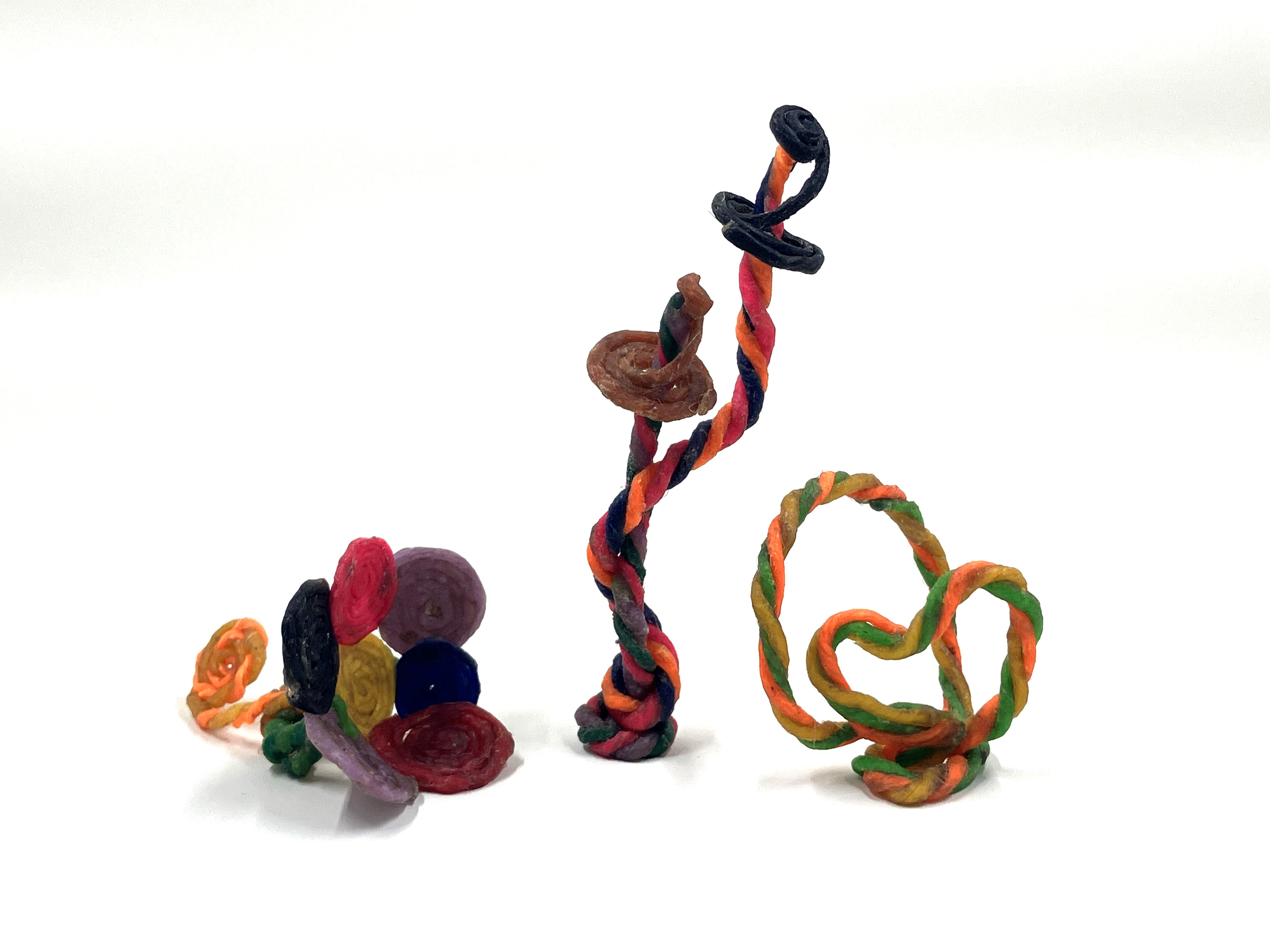 Various colourful sculptures are bent and folded in fun shapes against a white background