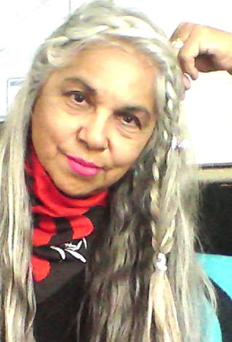 Woman with long grey hair grinning at the camera