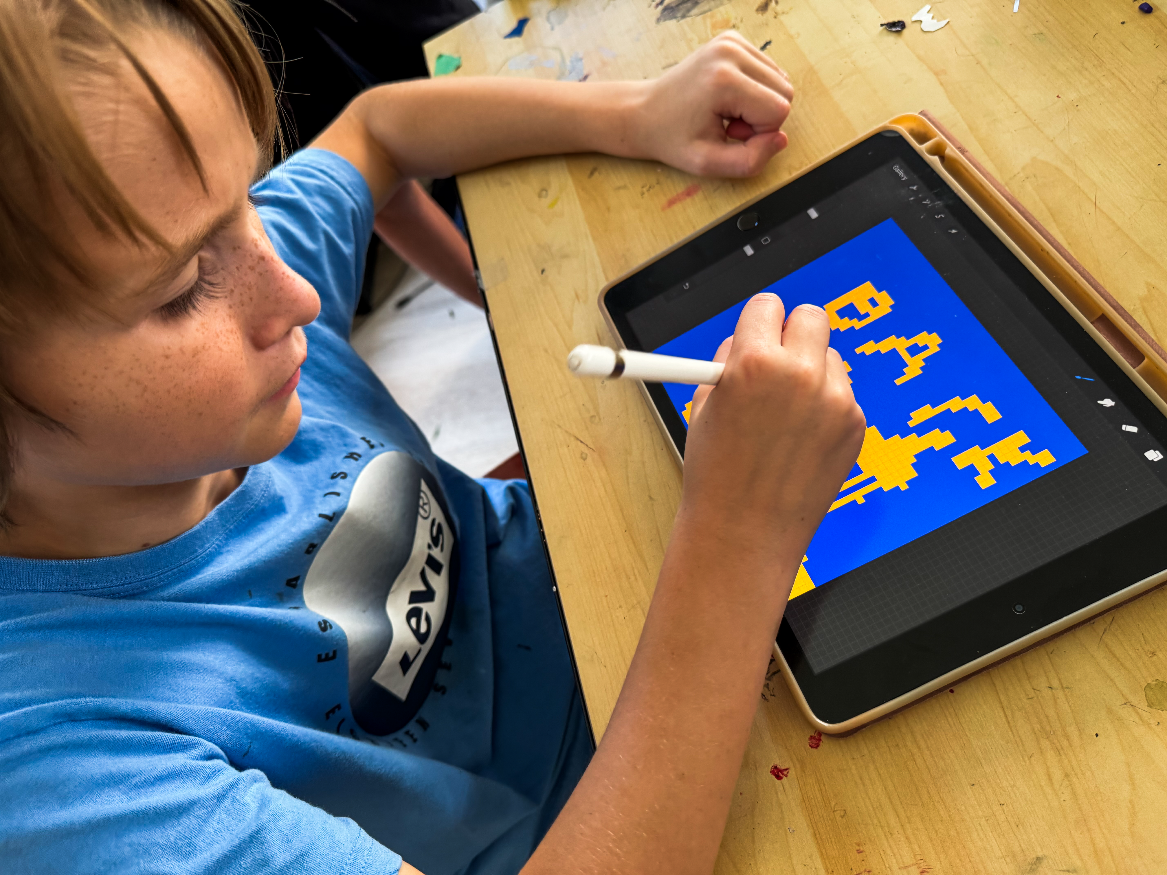Promo image for the Pixel Art program, featuring a child drawing with pixels on a digital tablet.