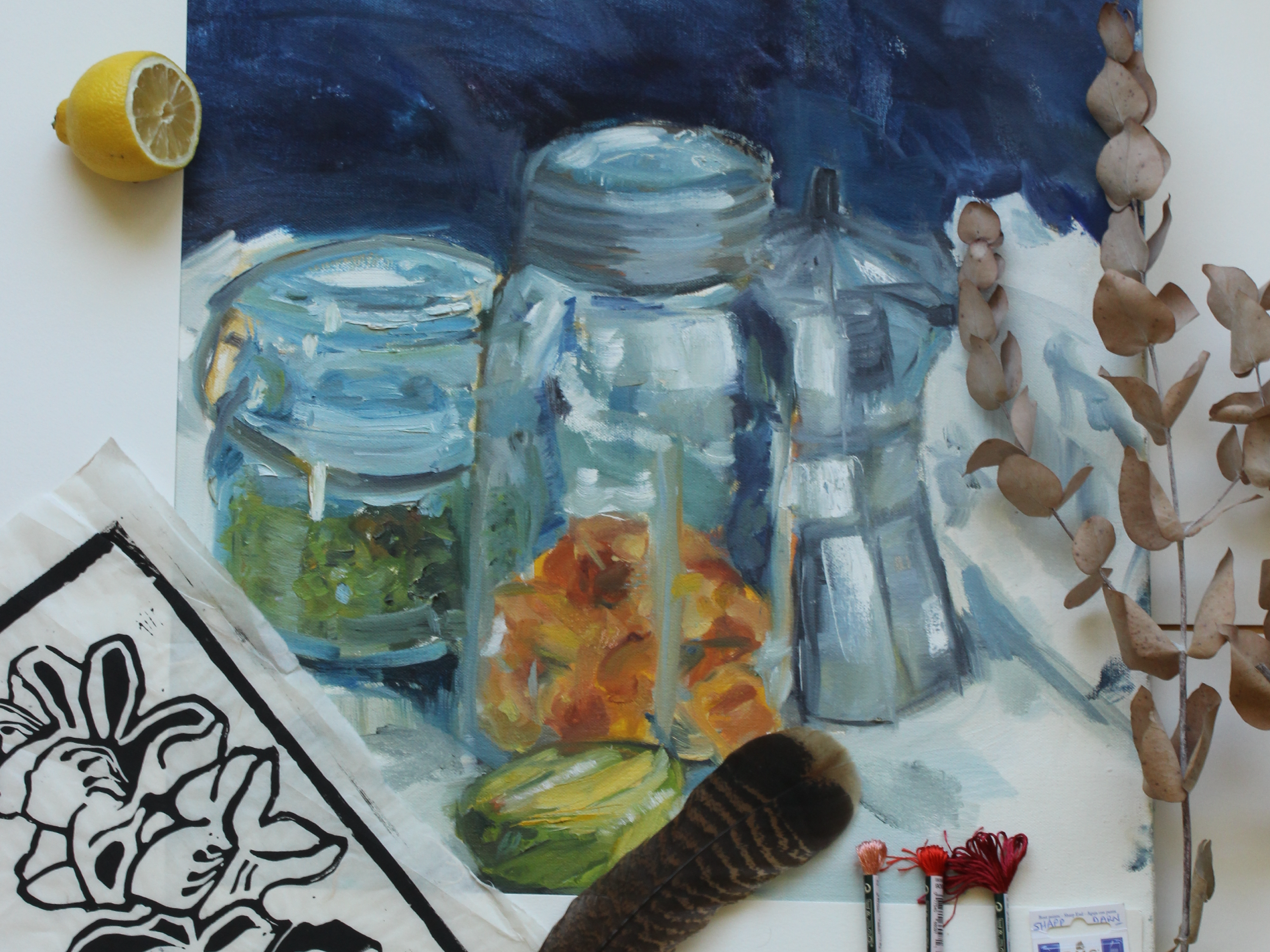 Painted still life of glass jars and kitchen objects surrounded by art-making materials.