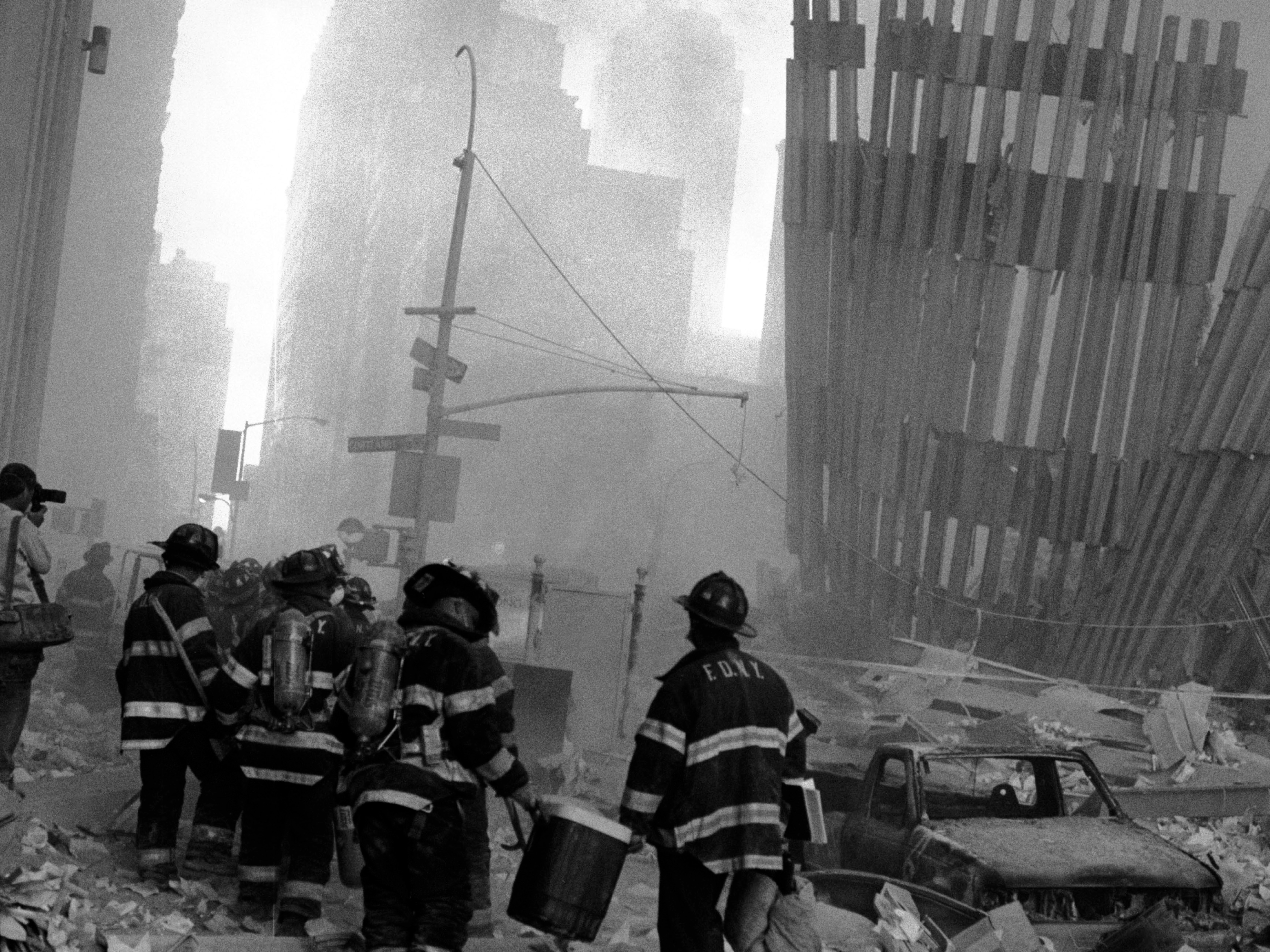 New York Firefighters stand amongst the rubble during the aftermath of 9/11.