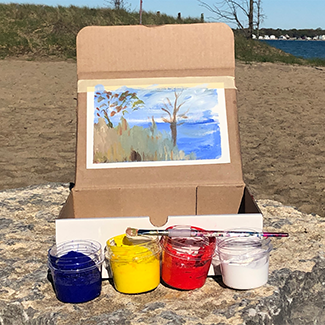 Painting of a tree taped to a box with jars of blue, yellow, red and white paint