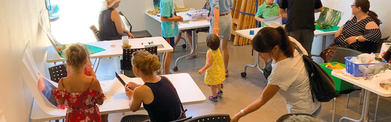 Families creating art in the art gallery studio as part of Family Sundays programming