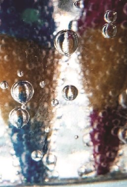 A close up of a blue and red pencil crayon behind water.