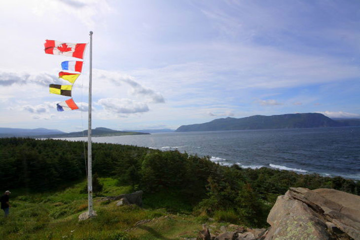 Flags on hillside overlooking water